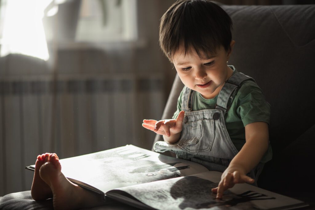 Niño pequeño aprende inglés leyendo un cuento